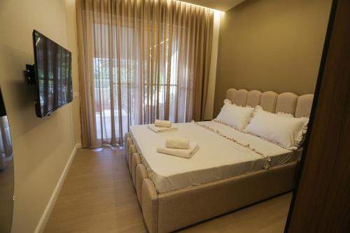 a bedroom with a large bed with two towels on it at Blue Coast Villa -Perla Resort in Lalëz