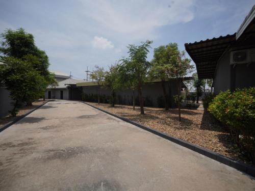 an empty driveway in a house with trees and houses at โรงแรมทูมอร์โรว์แลนด์ อมตะนคร in Ban Khlong Phan Thong