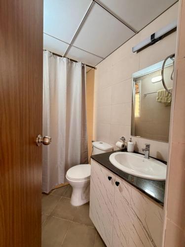 a bathroom with a sink and a toilet and a mirror at THE DUIN 1BR Apt Amoret Homes in Chicalim