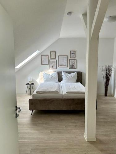 a bedroom with a bed with white sheets and pillows at Haus Knechtel in Stadtallendorf