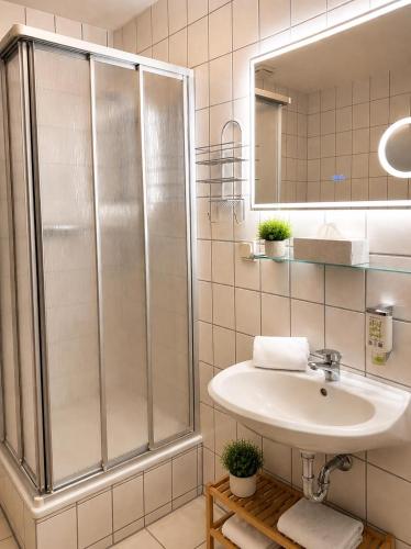 ein Badezimmer mit Waschbecken und Dusche in der Unterkunft Hotel Daheim in Gehlberg