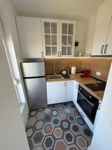 a small kitchen with white cabinets and a sink at Апартамент Солана - Apartment Solana in Lozenets