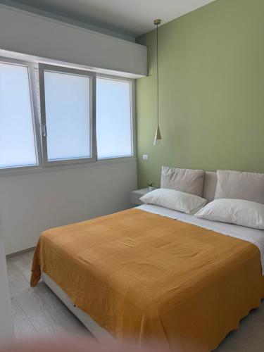 a bedroom with a large bed with two windows at Giovhome in Giovinazzo