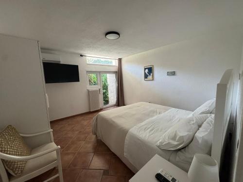 a bedroom with a white bed and a window at Apulian Way in Torre Pelosa