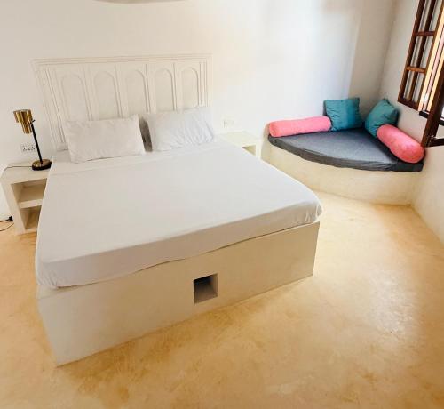 a bedroom with a bed and a couch at Two Bedroom Private Apartment in Shela, Lamu in Shela