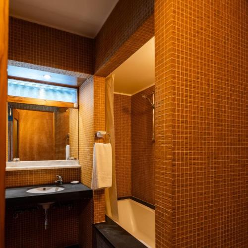 a bathroom with a sink and a shower and a mirror at Parque do Rio Ofir Hotel in Esposende