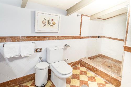 a white bathroom with a toilet and a shower at Labreña Hotel in Los Caños de Meca