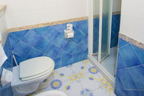 a blue tiled bathroom with a toilet and a shower at Hotel Terme Cristallo Palace in Casamicciola Terme