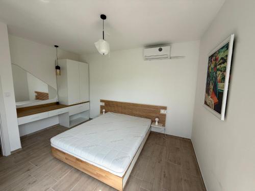a white room with a bed and a shelf at Вила Фамилия - Villa Family in Lozenets