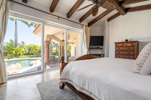 a bedroom with a large bed and a large window at Palmilla Golf and Beach Villa in San José del Cabo