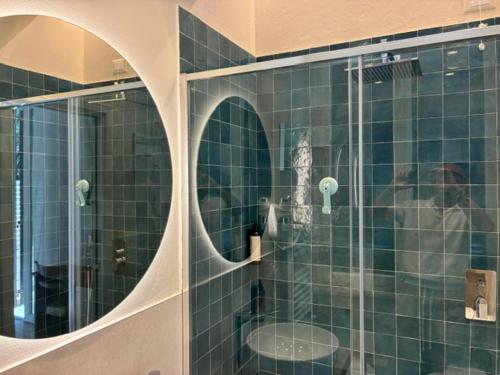 a man in a bathroom with a glass shower at Hotel Tirreno in Castiglioncello