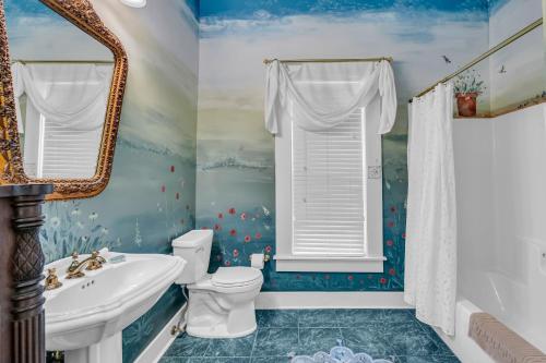 a bathroom with blue walls and a toilet and a sink at The Montgomery B&B in Starkville