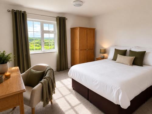 a bedroom with a bed and a chair and a window at Renard Lodge in Cahersiveen