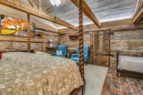 a bedroom with a bed and blue chairs at The Montgomery B&B in Starkville
