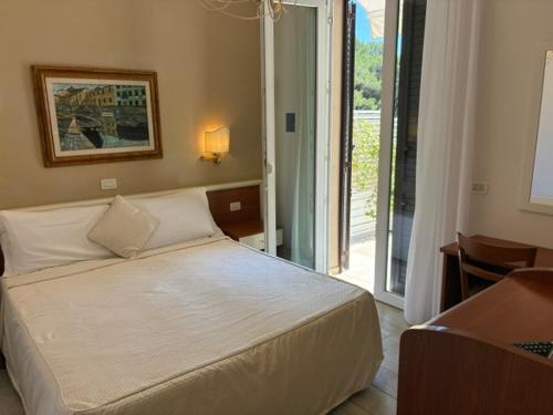 a bedroom with a bed and a sliding glass door at Hotel Tirreno in Castiglioncello