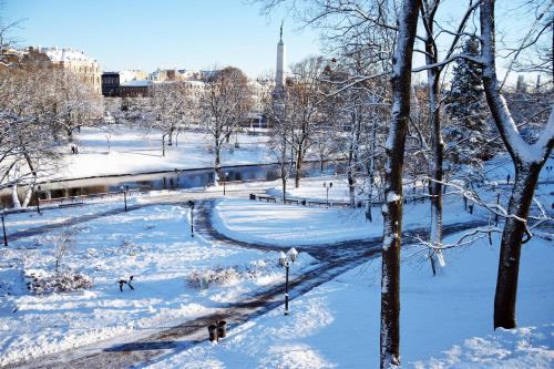 a snow covered park with people walking in the snow at Liberty Airy in Rīga
