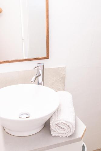 a bathroom with a white sink and a mirror at Ilot Bleu in Boucan Canot