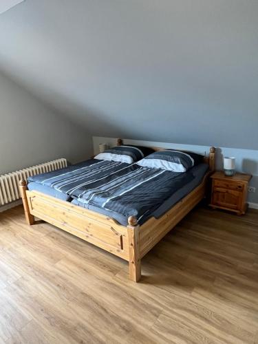 a bedroom with a wooden bed with blue sheets and pillows at Wohnung Ton Strand in Fehmarn