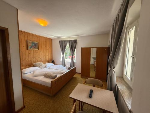 a bedroom with a large bed and a table at Hotel Mondschein in Plaus