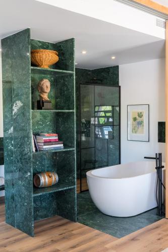 a bathroom with a tub and a glass wall at Quinta da Boa Esperança in Torres Vedras