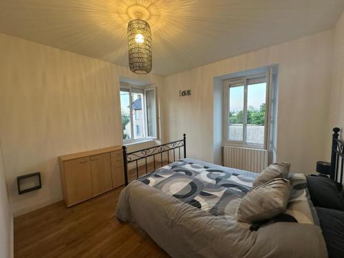 a bedroom with a large bed and a chandelier at Maison de maître in Bressuire