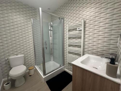 a bathroom with a toilet and a shower and a sink at Maison de maître in Bressuire
