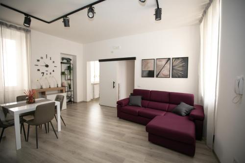 a living room with a purple couch and a table at Casa in Centro in Ascoli Piceno