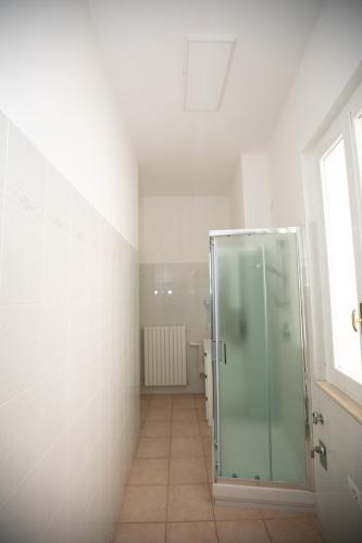 a bathroom with a glass shower and a tile floor at Casa in Centro in Ascoli Piceno