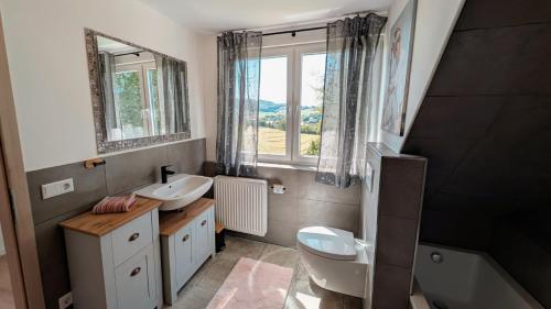 a bathroom with a sink and a toilet and a window at Idyllische Ferienwohnung im Kalletal in Kalletal