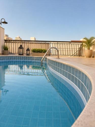 a swimming pool with blue tiles on a balcony at Hotel Mão de Fatima in Aparecida