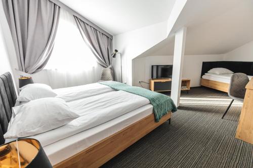 a bedroom with a large bed and a large window at Hotel Akwawit in Leszno