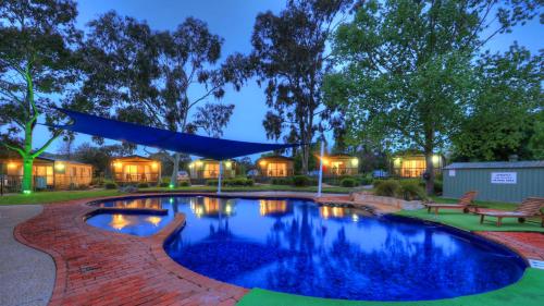 una piscina en un patio por la noche en Lake Hume Holiday Park en Lake Hume