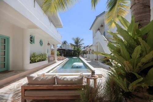a villa with a swimming pool next to a house at Quma Boutique Hotel - Adults Only in Gili Trawangan
