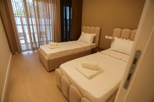 a small room with two beds and a window at Blue Coast - Villa 1 Perla Resort in Lalëz