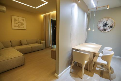 a living room with a table and chairs and a couch at Blue Coast - Villa 1 Perla Resort in Lalëz