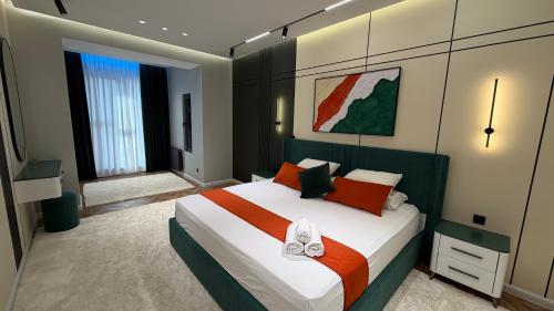 a bedroom with a large bed with orange and white pillows at Zafran Smart Luxury Suite in Dushanbe