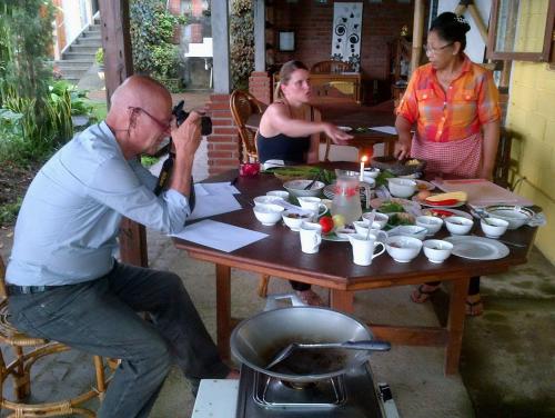 a man taking a picture of a table of food at KARANG SARI Guesthouse & Warung in Munduk