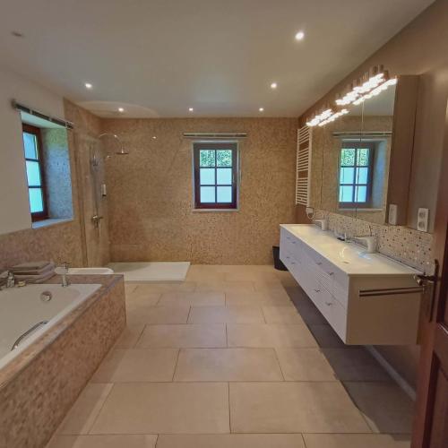 a large bathroom with two sinks and a tub at B&B Madoli in Érezée