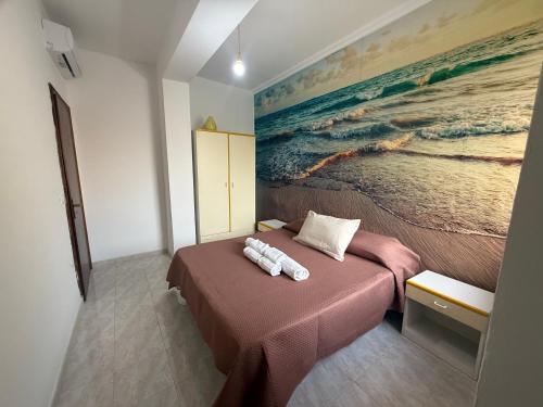 a bedroom with a bed with a painting on the wall at SeaMood Casa Vacanze in Praia a Mare