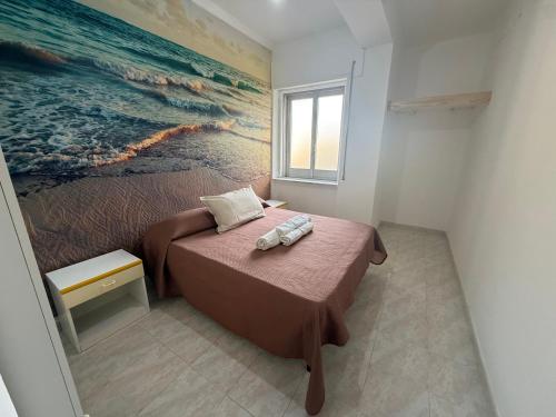 a bedroom with a bed with a painting on the wall at SeaMood Casa Vacanze in Praia a Mare