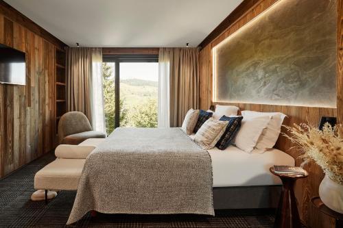 a bedroom with a bed and a large window at Les Chalets de l'Observatoire in Megève