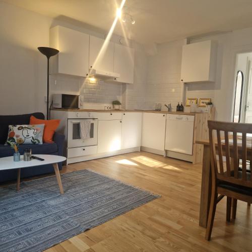 a living room with a blue couch and a kitchen at Central City Apartment A in Nyköping