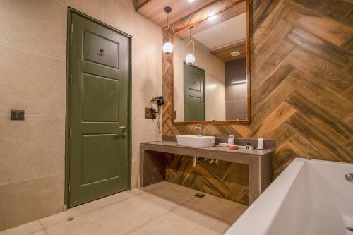 a bathroom with a green door and a sink at The Corbett Greens- A Wild Resort Muhaan in Tota Ām