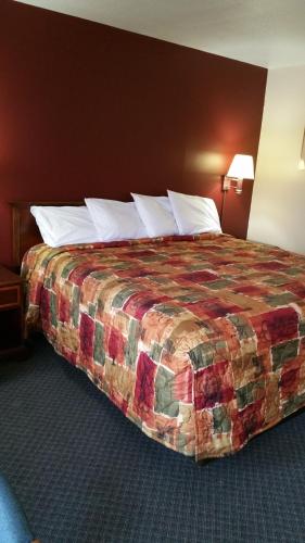 1 cama en una habitación de hotel con 1 cama grande en Foster Inn Monticello, en Monticello