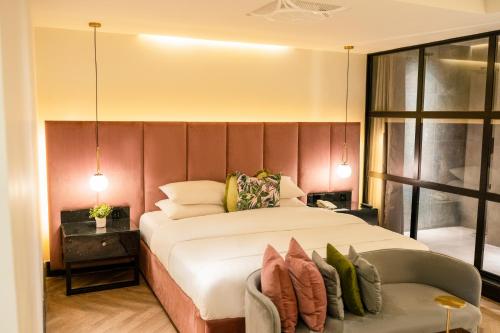 a bedroom with a large bed and a chair at City Hotel in Abbottabad