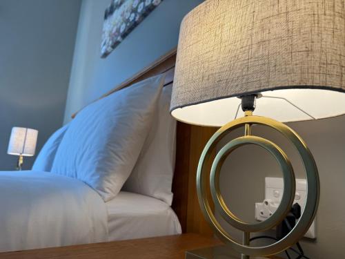 a lamp with a mirror on a table next to a bed at Angel Guest House in Maputo