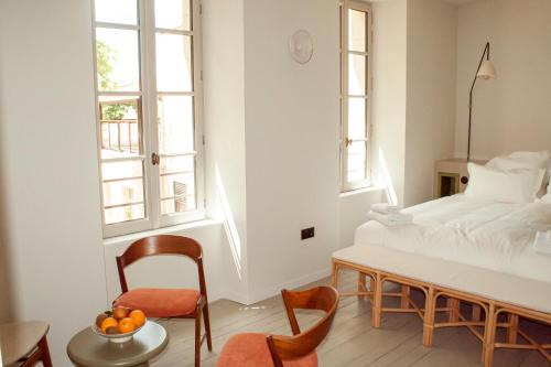 a bedroom with a bed and a table and chairs at Coureilles Appartements et Suites in La Rochelle