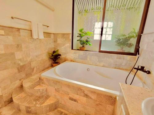 a large bathroom with a tub and a sink at Baan Golden Pool Villa in Sam Roi Yot