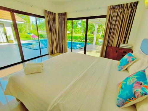a bedroom with a bed with a view of a pool at Baan Golden Pool Villa in Sam Roi Yot
