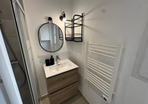 a bathroom with a sink and a mirror at T2 Calme et Moderne in Margny-lès-Compiègne